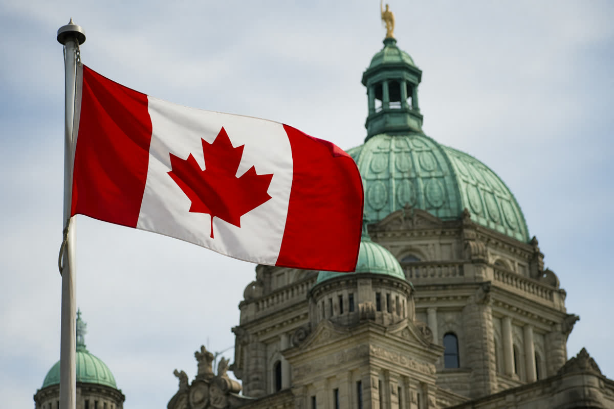 Drapeau canadien devant un édifice gouvernemental